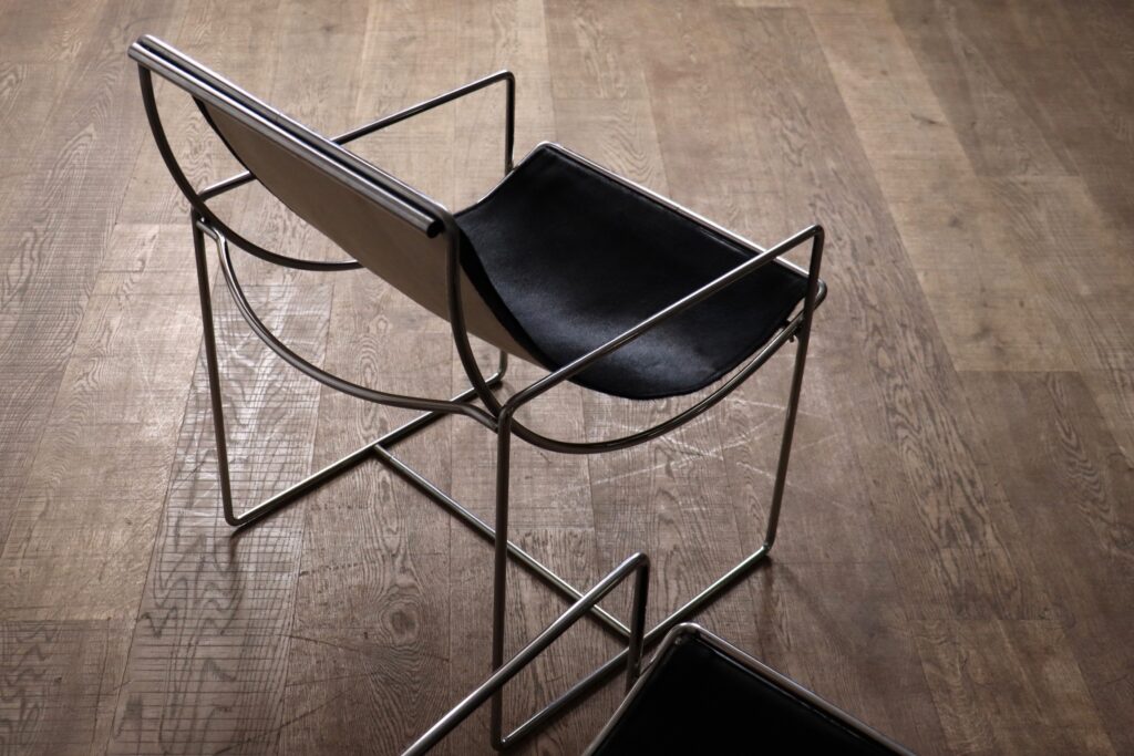 Detail of the black pony upholstery and chrome frame on the Odile Mir Filo chair.