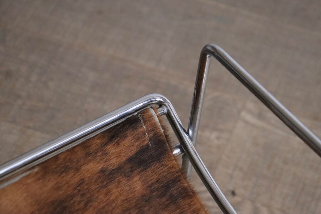Detail of the chrome frame and natural cowskin upholstery on the Odile Mir Filo chair.