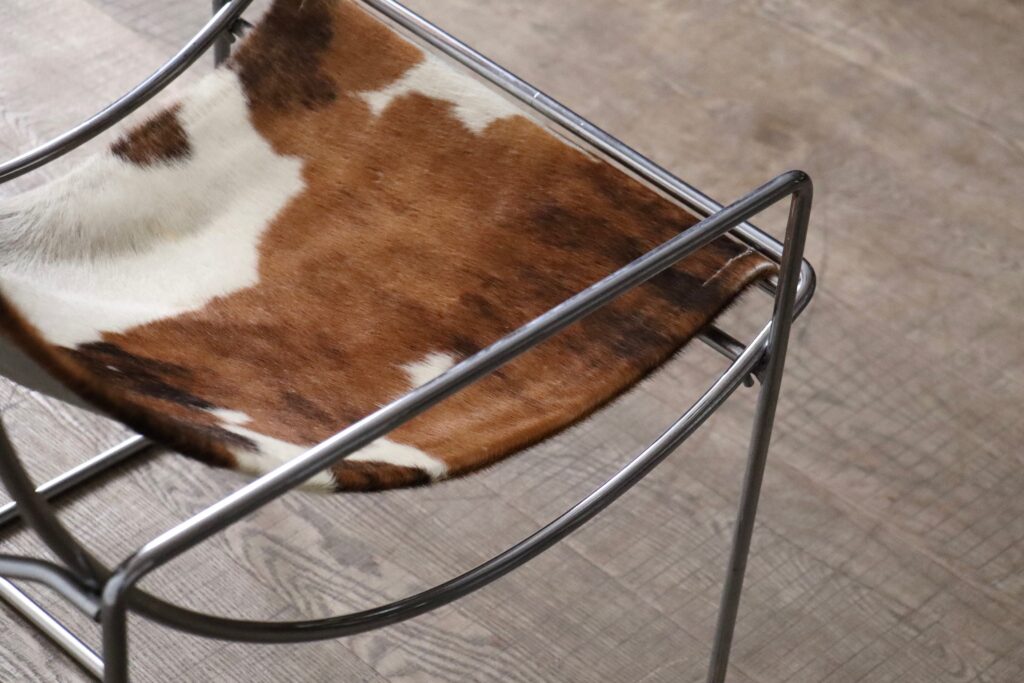 Detail of the chrome frame and natural cowskin upholstery on the Odile Mir Filo chair.