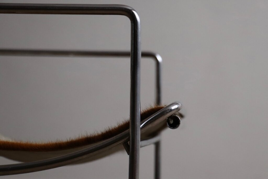 Detail of the chrome frame and natural cowskin upholstery on the Odile Mir Filo chair.
